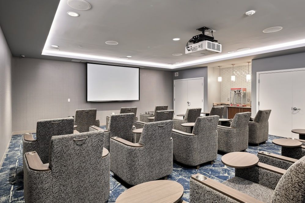 A modern conference room featuring comfortable seating and a projector setup.