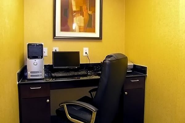 A tidy office space featuring a computer setup on a desk with a comfortable chair.