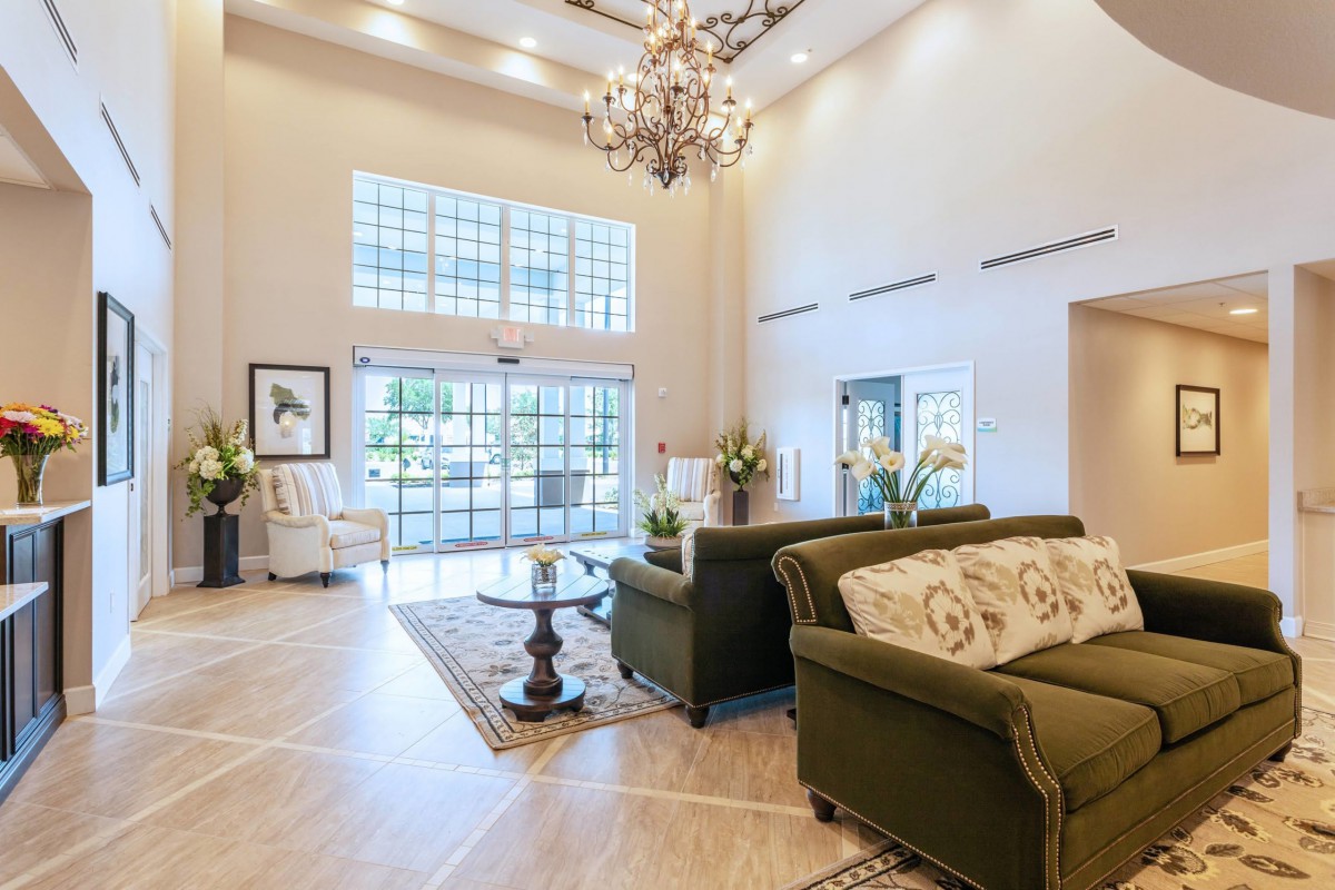 A bright and spacious lobby with a modern design featuring an elegant chandelier and comfortable seating.