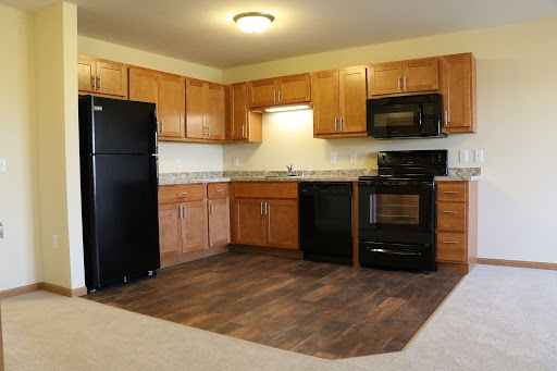 A modern kitchen featuring wooden cabinets, black appliances, and a spacious layout.