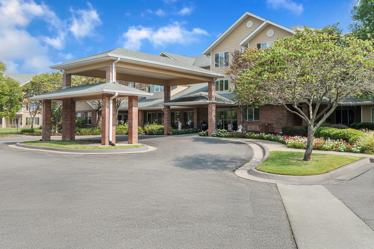 A welcoming entrance to a modern building with landscaped surroundings.