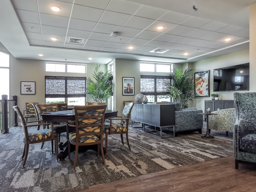 A modern living room and dining area with ample natural light and stylish furniture.