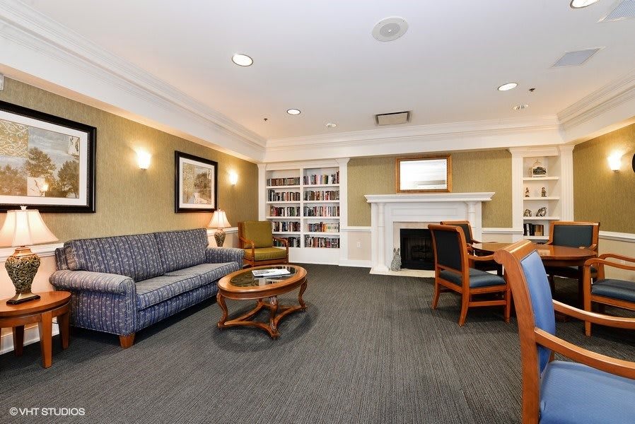 A cozy living room with a sofa, fireplace, and bookshelf.