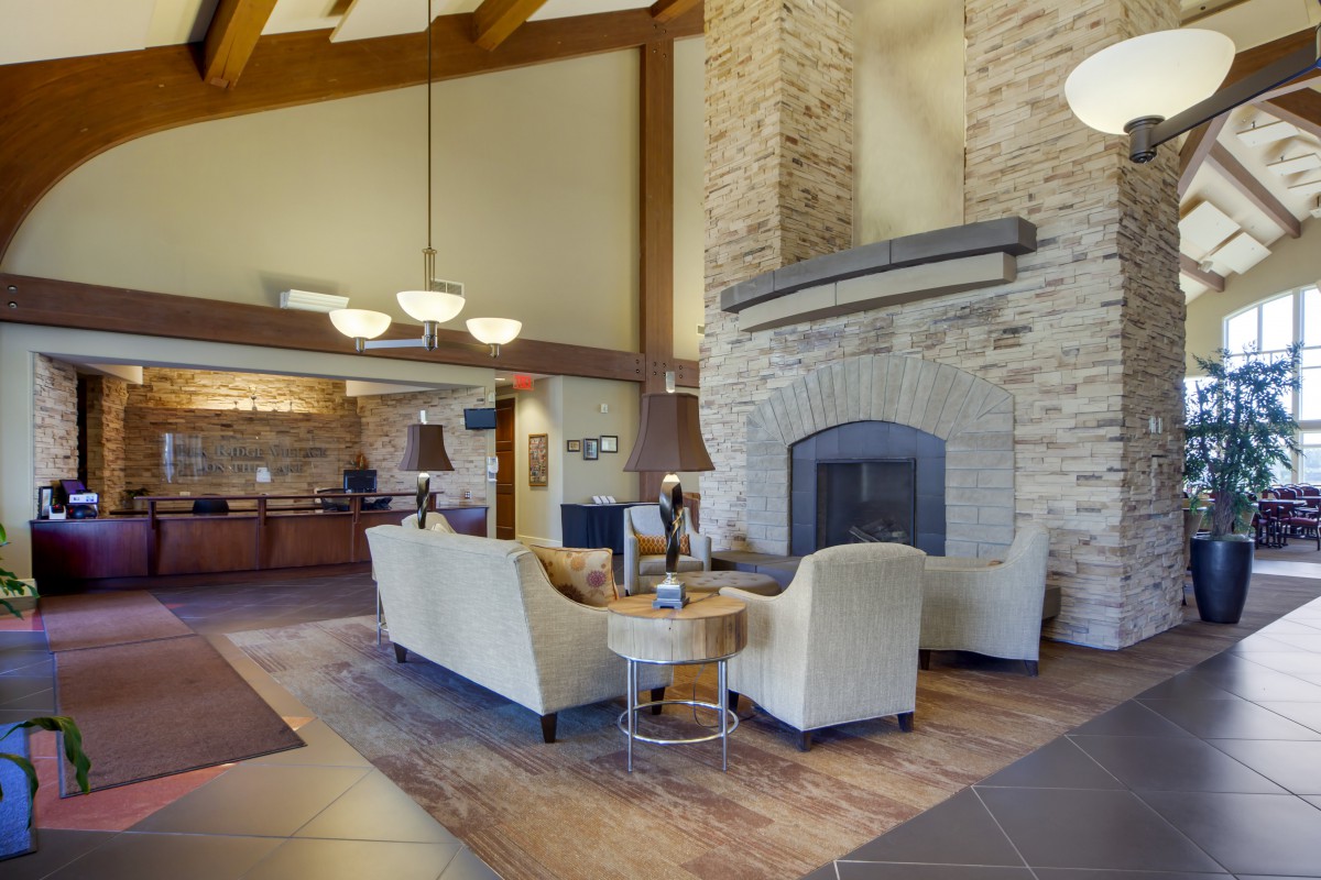 A modern lobby featuring a cozy seating area with a fireplace and elegant lighting.