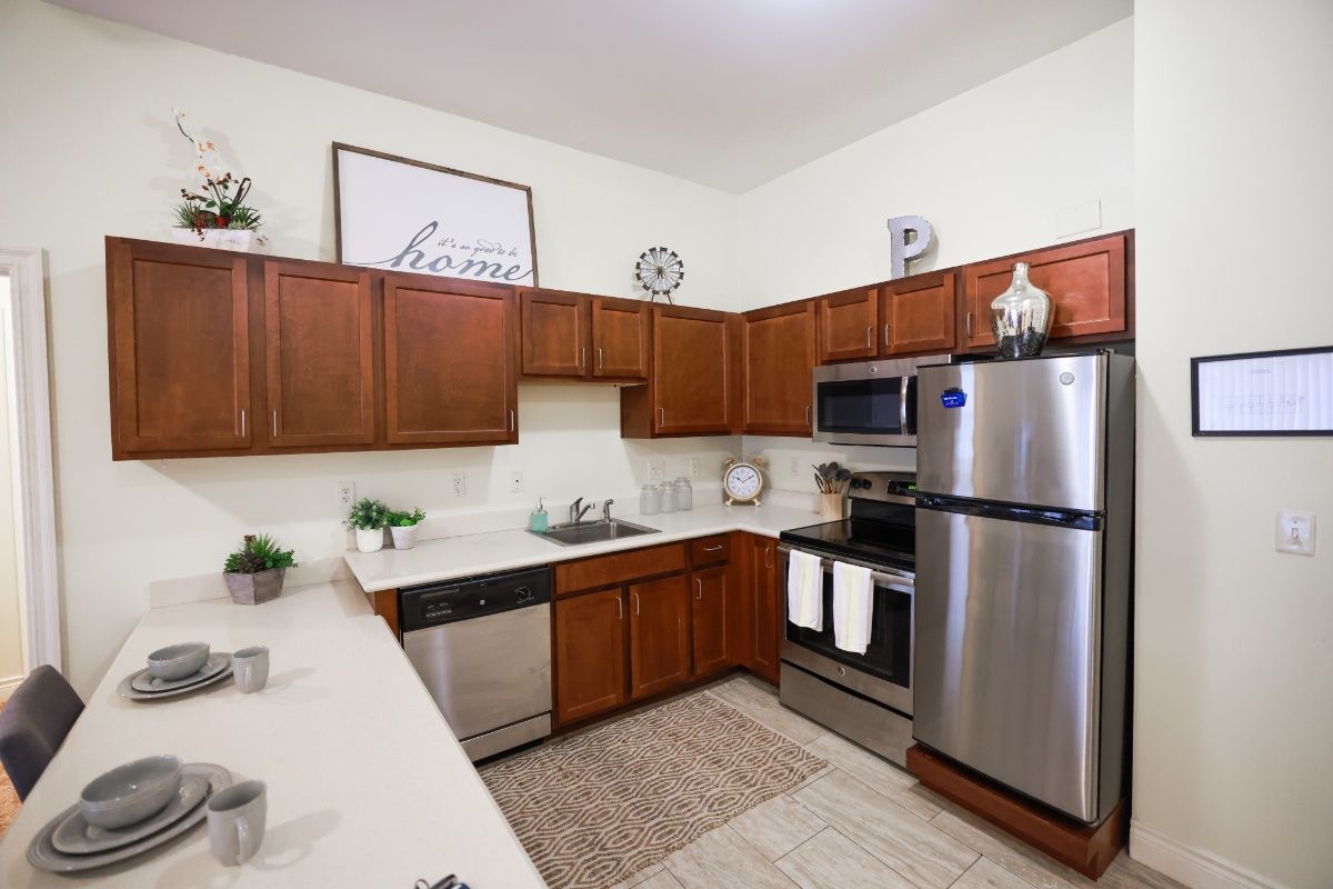 A modern kitchen with wooden cabinets and stainless steel appliances.