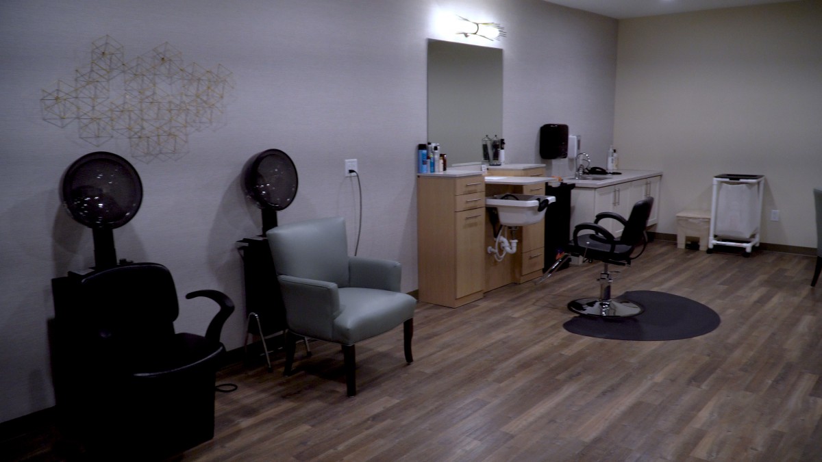 A modern salon interior featuring chairs, mirrors, and hair styling equipment.
