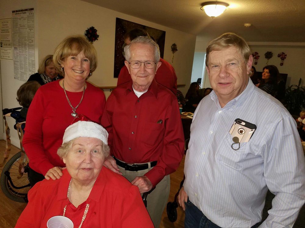A group of elderly individuals gathered indoors, posing for a photo.