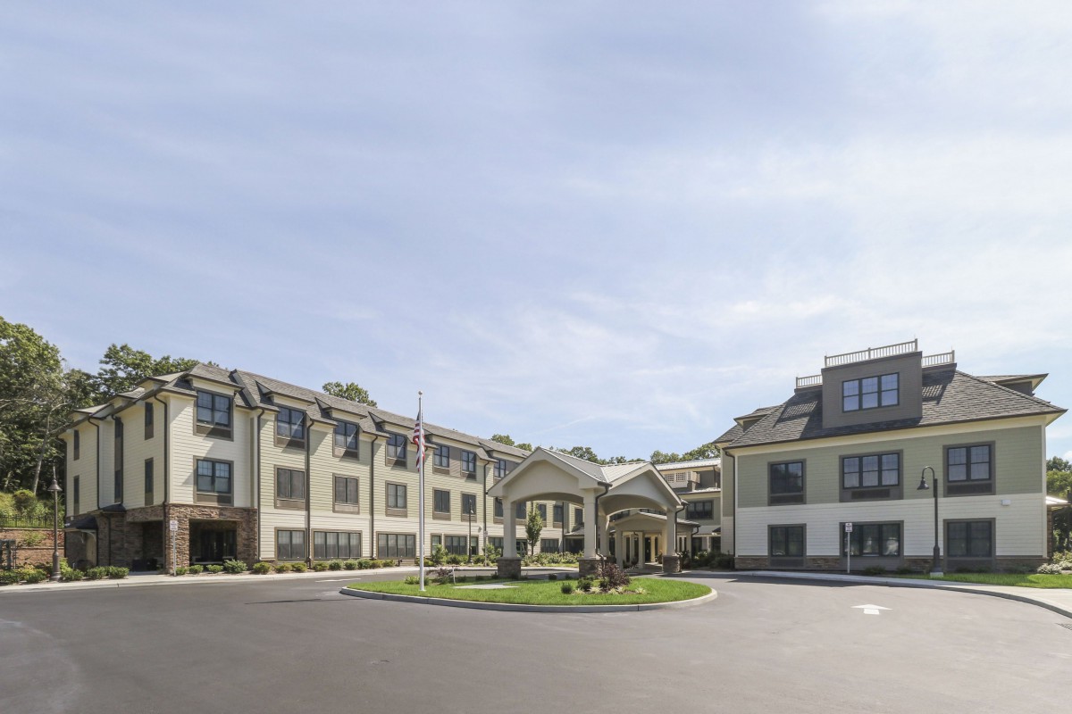 A well-maintained hotel or residential building with landscaped surroundings.