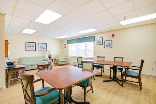 A well-lit lounge area featuring wooden tables and comfortable seating, designed for relaxation and socializing.
