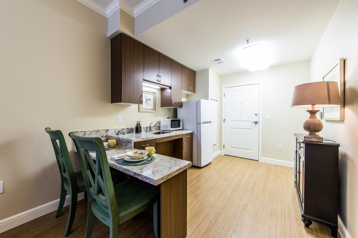 A modern, compact kitchen and dining area in an apartment setting.