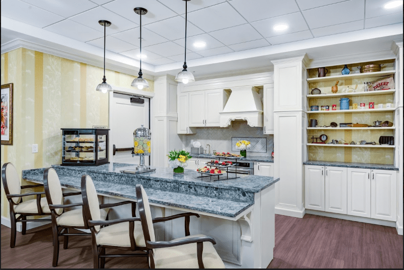 A modern kitchen featuring a central island with pendant lighting and white cabinetry.
