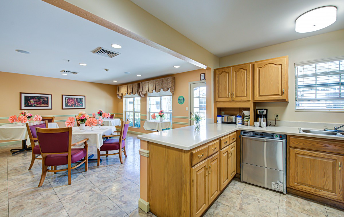 A cozy kitchen and dining area with wooden cabinets, a countertop, and modern appliances.