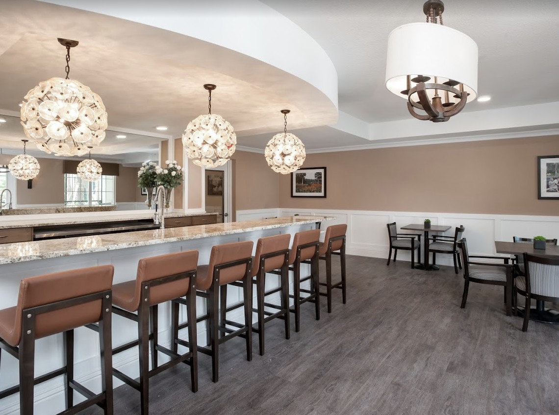 A modern bar area with pendant lighting and seating at the counter.