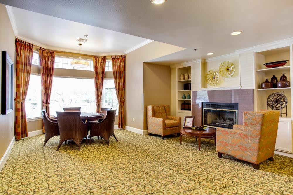 A cozy living room with a fireplace, comfortable seating, and a dining table.