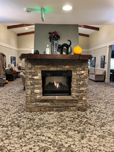 A cozy living room with a stone fireplace and comfortable seating.