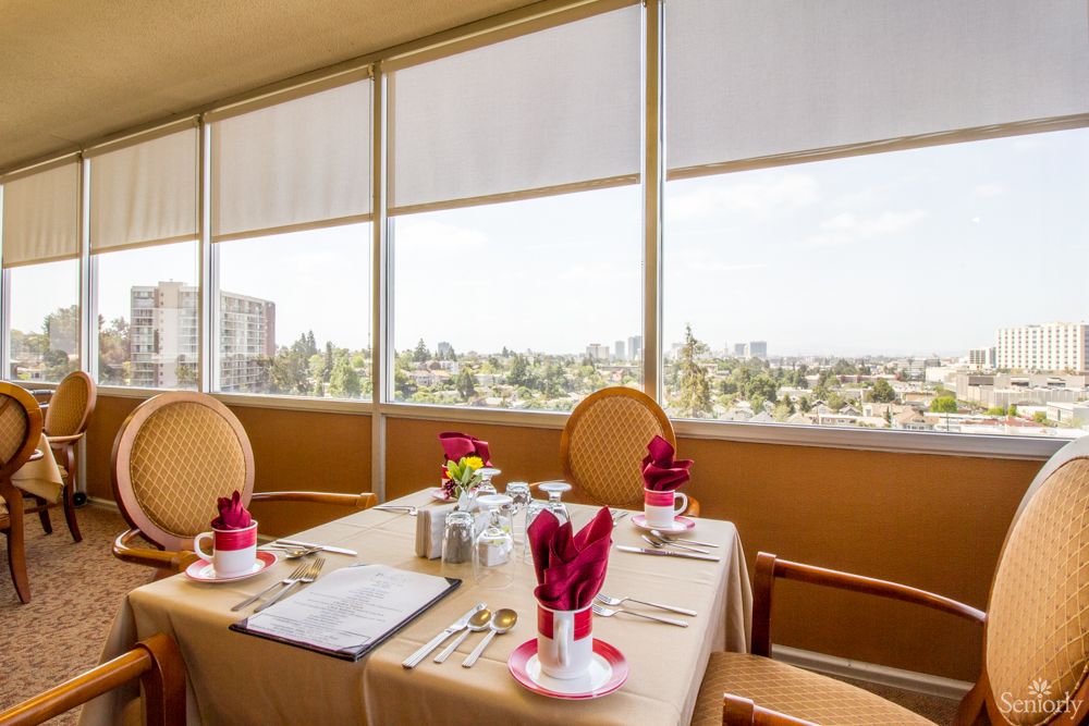 Elegant dining table with a city view through large windows.