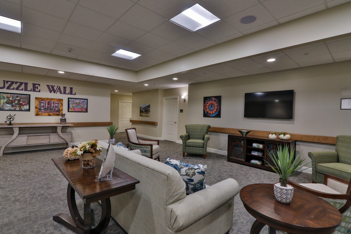 A comfortable lobby with seating arrangements, a television, and decorative elements.