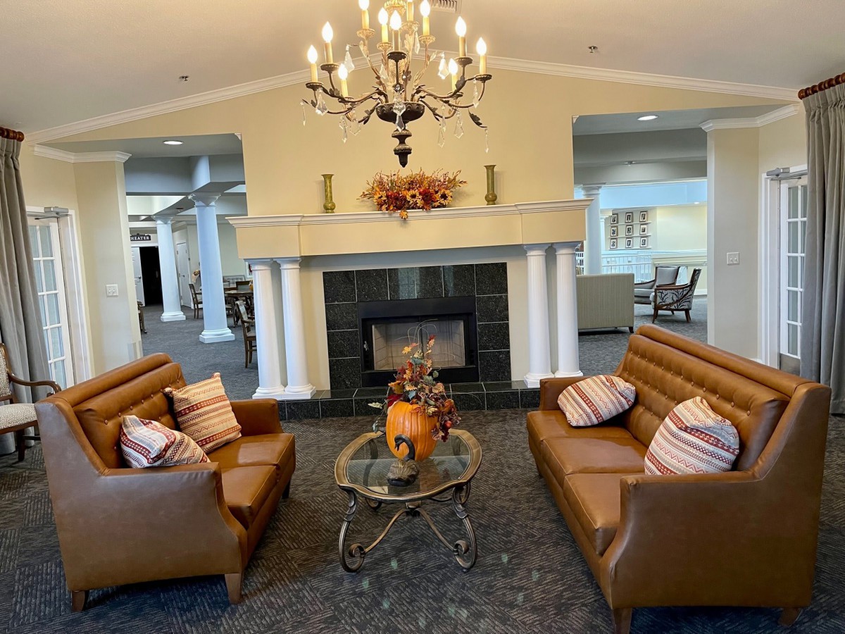 A cozy living room with elegant furnishings and a central fireplace.