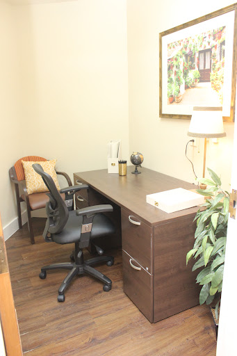 A cozy office space with a desk, ergonomic chair, and decorative elements.