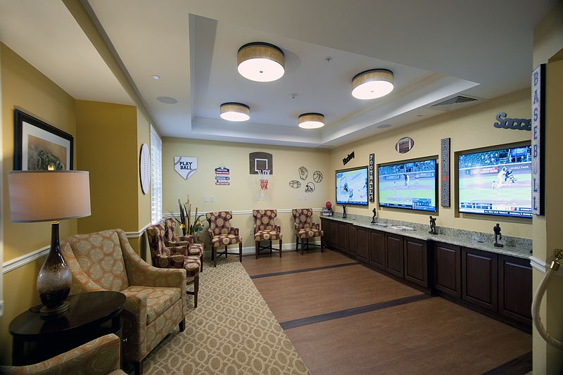 A modern lounge area featuring multiple seating options and large screen televisions for entertainment.