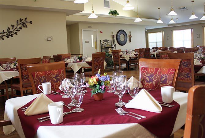 Elegant dining room with a neatly arranged table setting and decorative elements.
