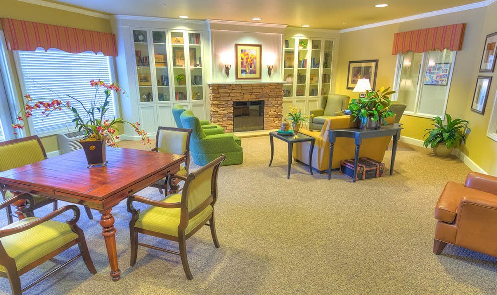A cozy living room featuring a fireplace, comfortable seating, and bookshelves filled with decor.