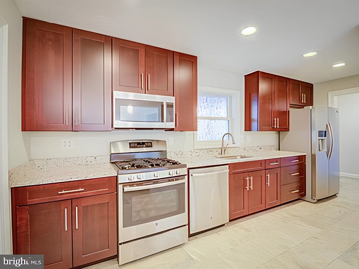 A modern kitchen featuring wooden cabinets and stainless steel appliances.