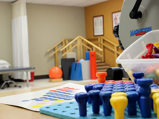 A well-equipped therapy room featuring colorful tools for rehabilitation and sensory activities.