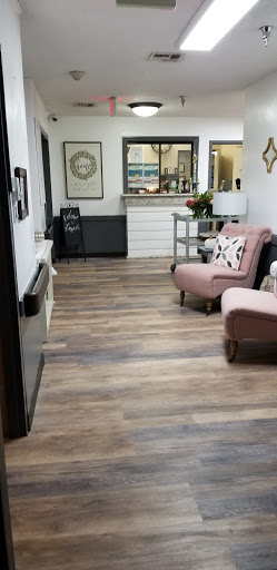 A cozy living room featuring elegant pink chairs and wooden flooring, exuding warmth and style.