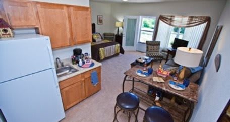 A cozy studio apartment featuring a compact kitchen and a comfortable living area.