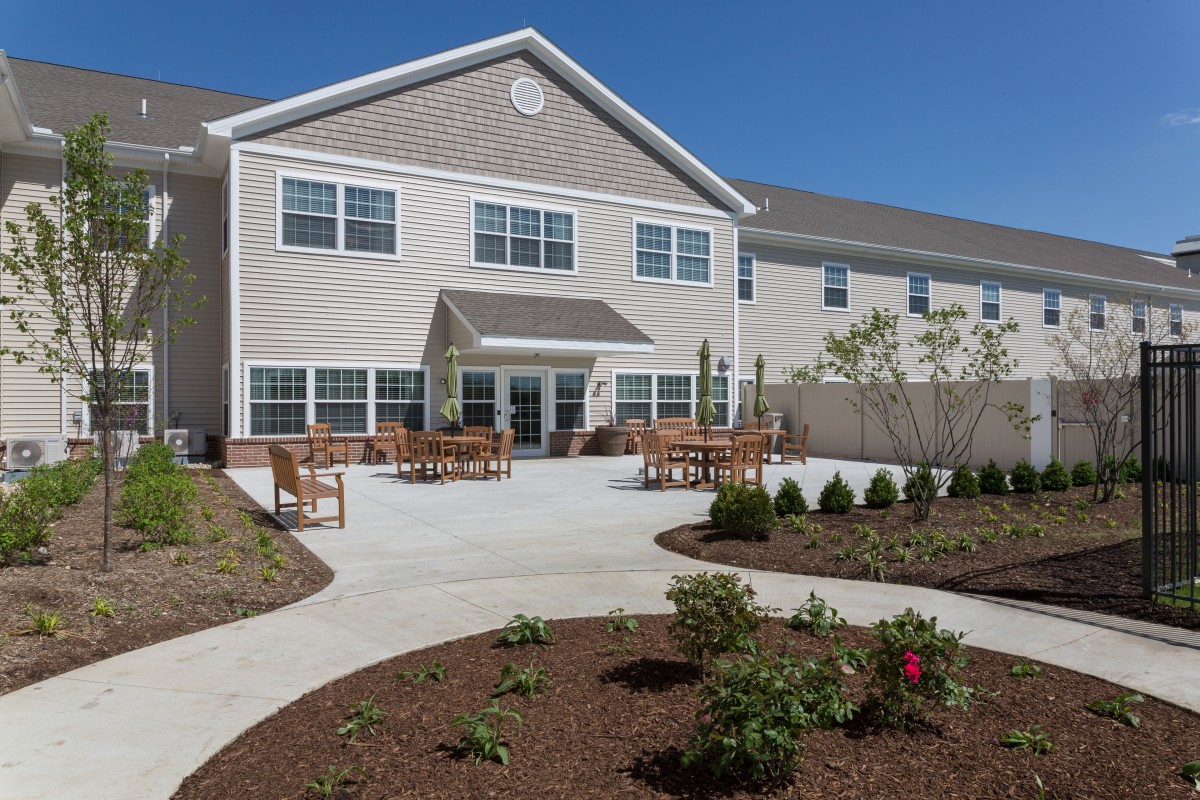 A residential building with a landscaped garden and outdoor seating area.