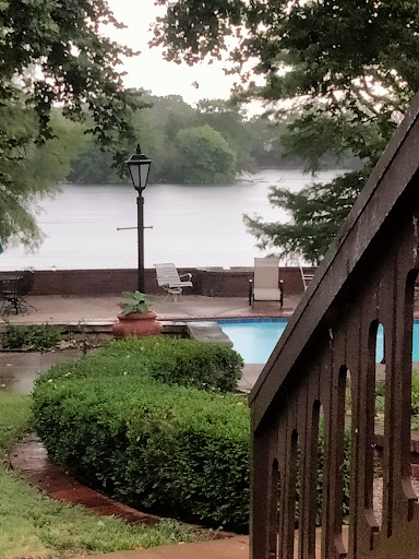 A serene view of a poolside garden overlooking a calm body of water.