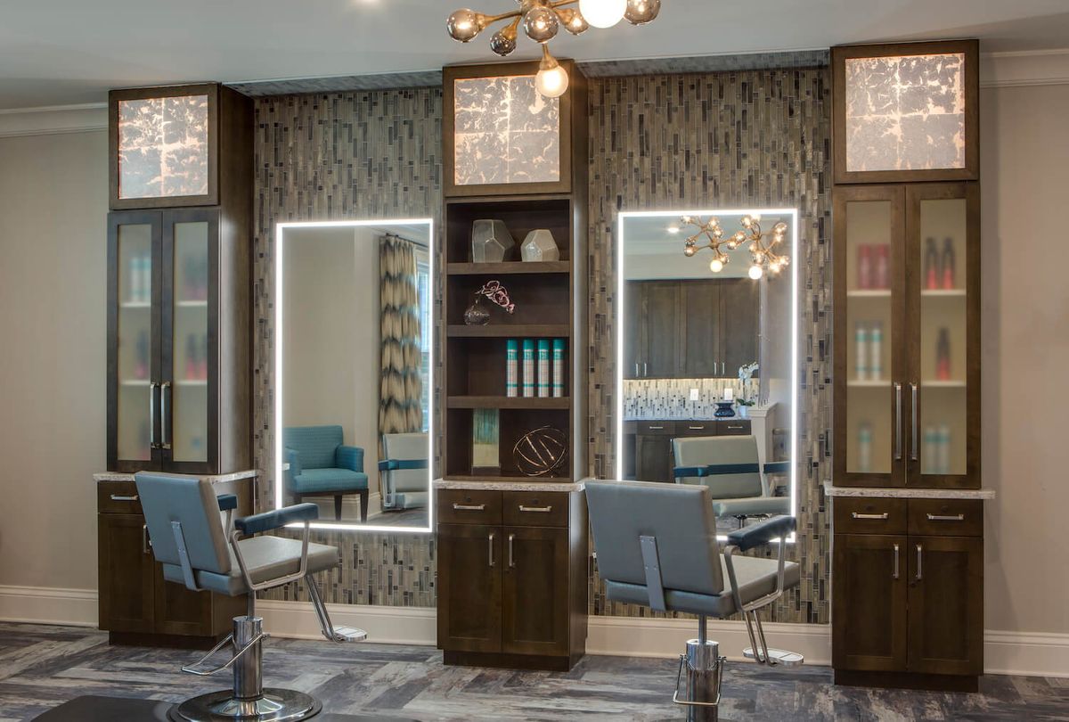 A modern hair salon interior with stylish mirrors and comfortable chairs.