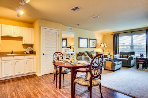 A cozy living space with a dining table, comfortable seating, and a small kitchen area.