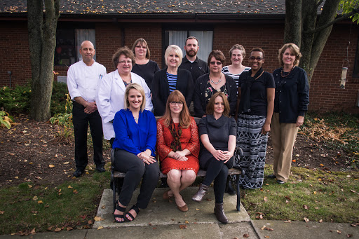 A group of professionals posing for a team photograph in an outdoor setting.