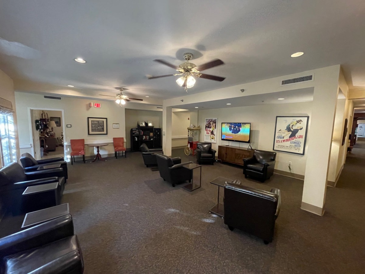 A cozy lounge area with comfortable seating, a flat-screen TV, and decorative posters on the walls.