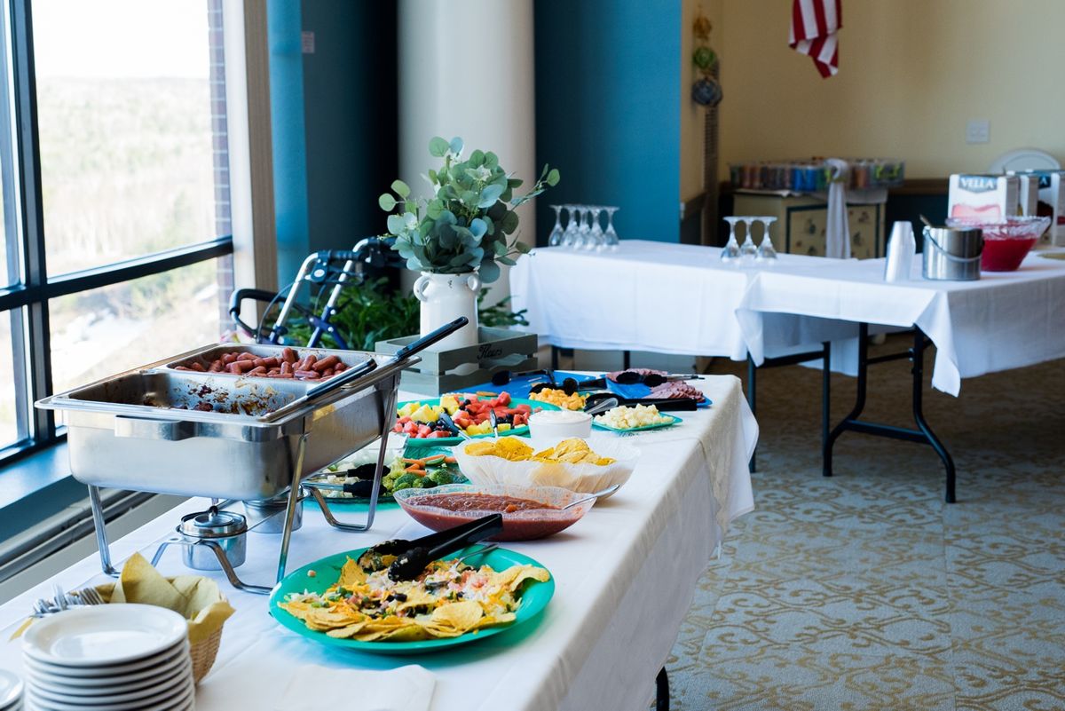A buffet table set up for an event, featuring a variety of dishes and glassware.