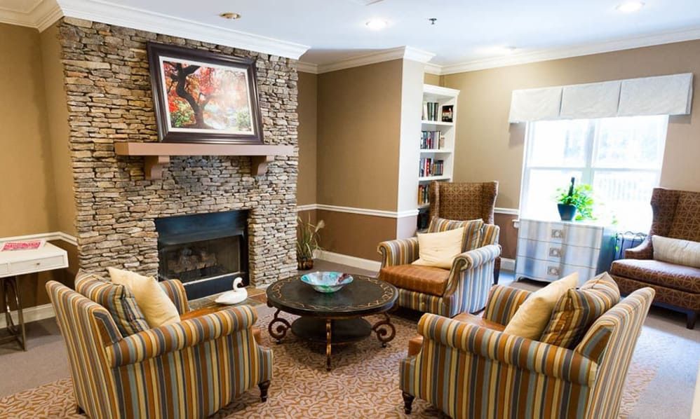 A cozy living room featuring a stone fireplace, comfortable armchairs, and stylish decor.