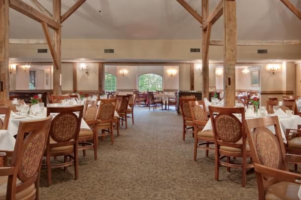A spacious restaurant dining area with neatly arranged wooden tables and chairs.