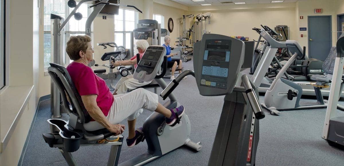 People exercising on gym equipment in a fitness center.