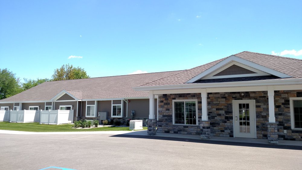A modern, single-story residential building with a garage and driveway.