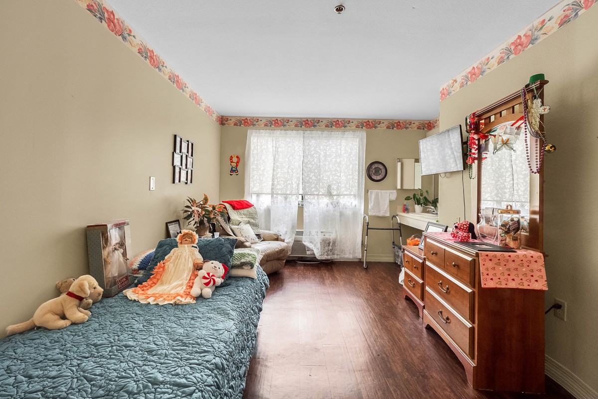 A cozy bedroom with a bed, dresser, and various decorations.