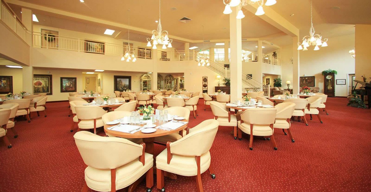 An elegant dining area with upholstered chairs and chandeliers.