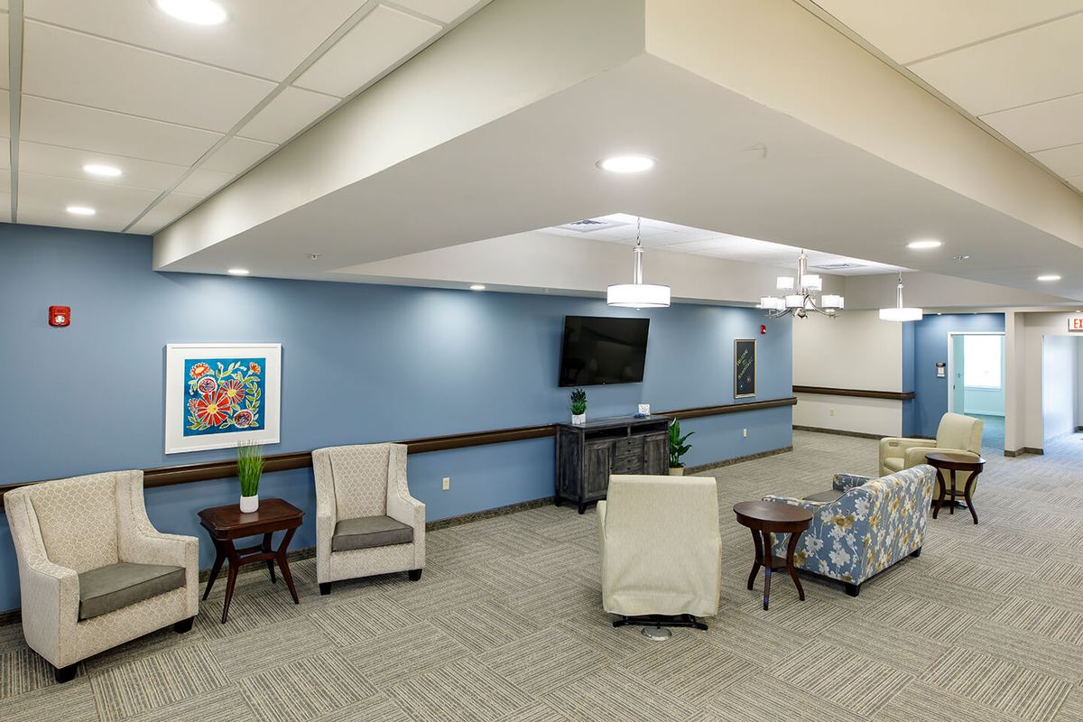 A well-lit lounge featuring comfortable seating, a television, and stylish decor.