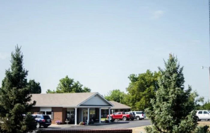 A suburban building with cars parked outside on a sunny day.