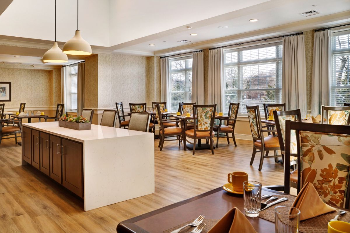 A modern dining room with elegant furniture and large windows providing natural light.
