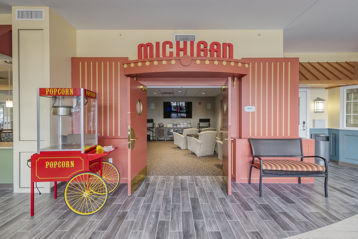Entrance to a retro-themed movie theater with a popcorn machine and a Michigan sign.