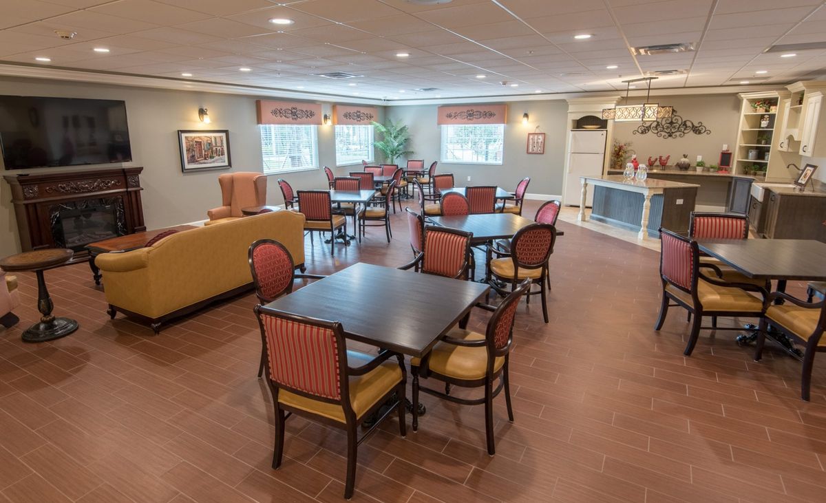 A cozy and well-furnished dining room with tables and chairs, complete with large windows and tasteful decor.