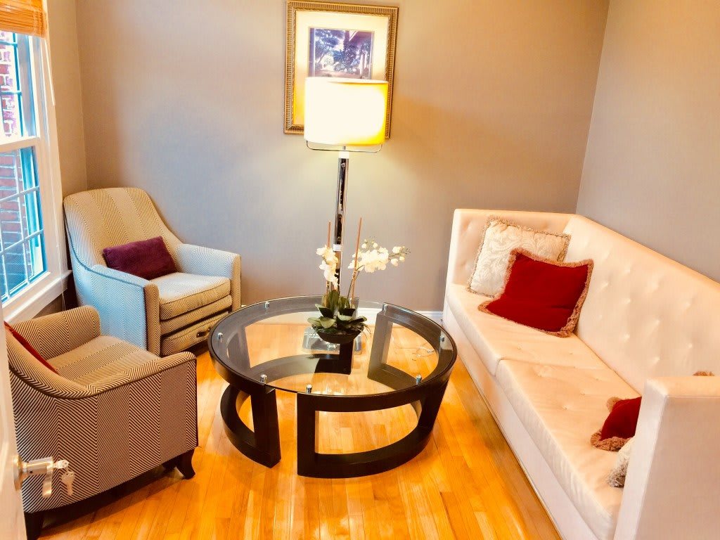 A cozy living room with a sofa, armchair, and modern coffee table.