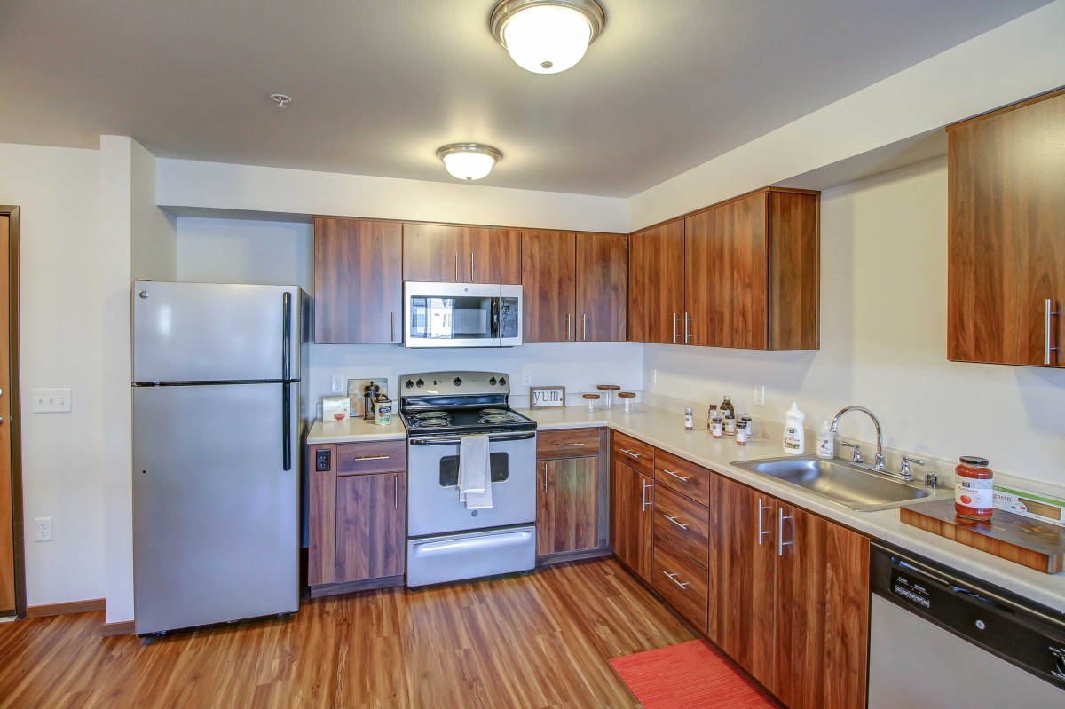 A modern kitchen with stainless steel appliances and wooden cabinetry.